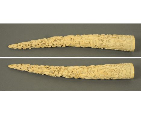 A 19th century Chinese carved ivory tusk, Canton, intricately carved with figures, buildings, foliage and mountains.  Height 