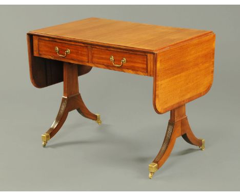 A mahogany sofa table, in the George III style, with crossbanded edge and recessed frieze, fitted with two drawers and raised