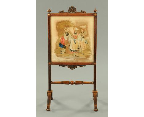A Victorian rosewood fire screen, with woolwork tapestry panel, with turned stretcher and raised on downswept legs.