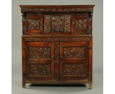 An antique oak court cupboard, with Westmorland scroll carving, with date to frieze 1572, with some alterations.  Width 151 c