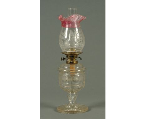 A Victorian glass oil lamp, with trailed ruby and etched glass shade.  Height including chimney 57 cm.  