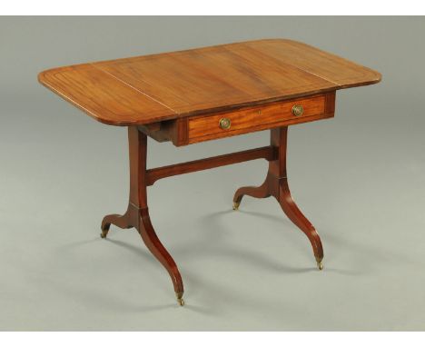 A Regency mahogany sofa table, ebony strung, with frieze drawer with brass knob handles, each flap with rounded corners and r