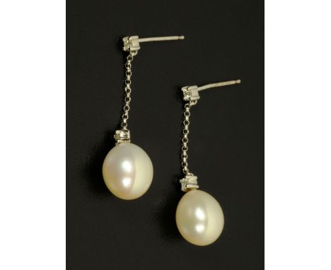 A pair of 14 ct white gold pearl earrings, each pearl suspended from a chain set with two small diamonds.  Length 33 mm.