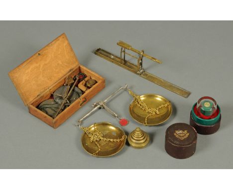 A sovereign scale, two balance scales, weights and measuring glass.