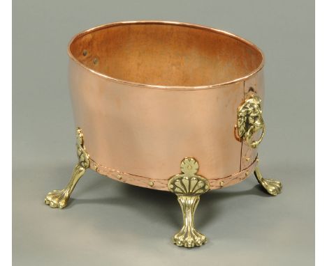 A Victorian brass and copper oval planter or coal receiver, with lions mask handles and paw feet.  Width 41 cm. 