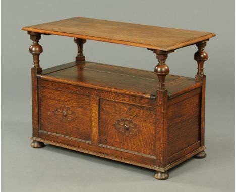 An oak monks bench, typical form, with folding top, box seat and with panelled front.  Width 96 cm. 