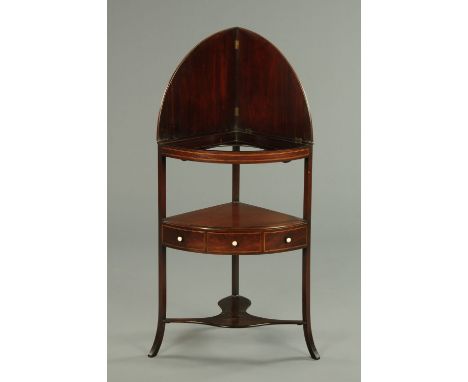 A George III mahogany corner washstand, with folding splashback, frieze drawer and raised on splayed legs with low shaped she