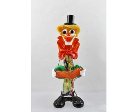 A MID TO LATE 20TH CENTURY MURANO GLASS CLOWN, playing an accordion, wearing a black top hat, orange bow tie and with typical