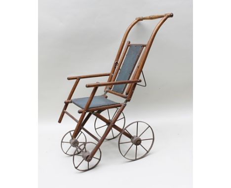 A VICTORIAN DESIGN WOODEN FRAMED DOLL'S FOLDING PUSH CHAIR raised on metal wheels (collector's item only) 69cm high 