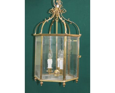 A 20TH CENTURY REGENCY DESIGN BRASS FRAMED HALL LANTERN of hexagonal form with bevelled glass panels, three lamp fittings, wi