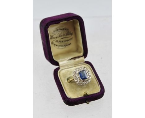 A SAPPHIRE AND DIAMOND RING, having central cushion cut sapphire (7mm x 5mm) surrounded by a double row of diamonds, on an 18