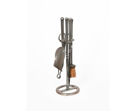 A Cotswold School set of fire tools,  comprising tongs, brush poler and shovel on  stand, all wrought with twisted stem and h