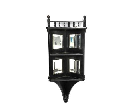 An Aesthetic Movement ebonised wood corner cabinet,  two triangular shelves below turned bobbin rail, the back set with four 