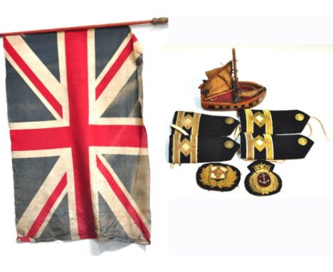 A weighted British military flag on pole, a small quantity of naval epaulettes and a small vintage wooden boat (af) (3).