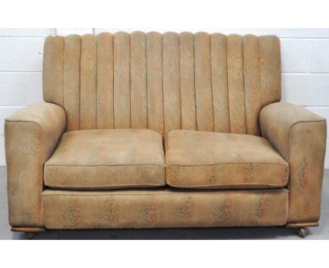 A 1930/40s beige upholstered two seat sofa, width 140cm and a pair of matching armchairs, all on castors (3).