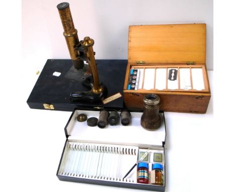 An early 20th century monocular microscope with an Ernst Leitz eyepiece lens, a quantity of additional unnamed lenses and a q