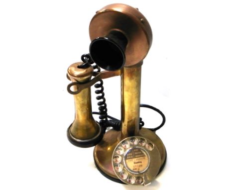 A vintage brass stick telephone.