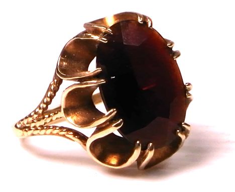 A 9ct gold ring set with a deep red oval stone, size k, approx weight 4.2g.