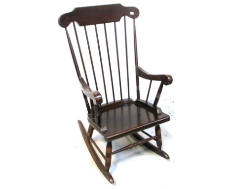 An Ercol style stick back rocking chair on ring turned supports.