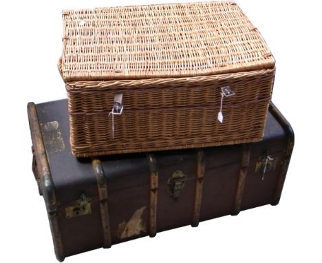 A vintage travelling trunk bearing various luggage labels to include one for the London and North Eastern railway and a wicke