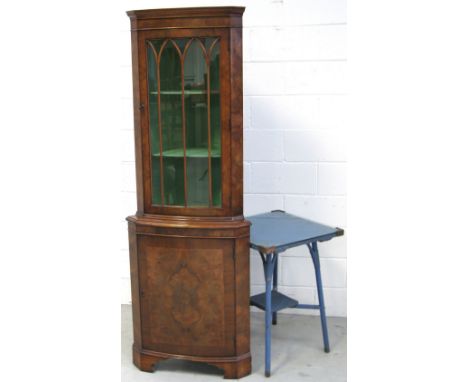 A reproduction walnut bow fronted free standing corner cupboard and a blue painted Lloyd Loom style glass top occasional tabl