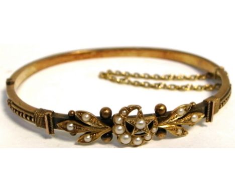 A 15ct gold bangle set with seed pearls in floral and star design. CONDITION REPORT Approx weight 7.5g. Small pearl missing b