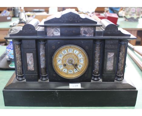 A black and variegated marble striking mantel clock