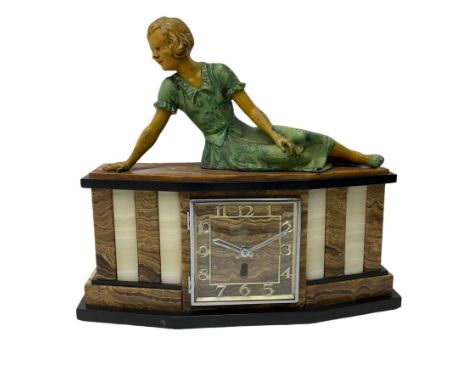 A 1950's Art Deco mantle clock in contrasting black, white and brown onyx marble, surmounted by a reclining spelter figure of