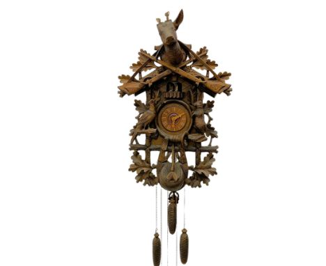 A large and imposing 20th century three train 30hr cuckoo clock with automata and musical features, profusely carved case wit