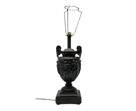 Neo classical style black painted twin handled lamp, decorated with classical scenes, with pedestal base raised upon shaped s