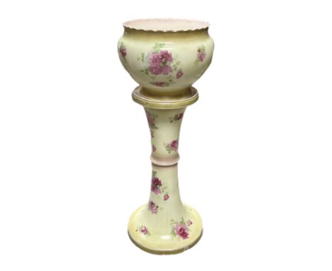 An early 20th century ceramic jardiniere on stand, each decorated with pink roses upon a yellow ground, overall H93cm.