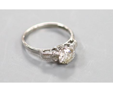  A white metal(stamped platinum) and single stone diamond ring with baguette and round cut diamond set shoulders,size N, gro