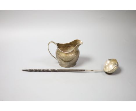   A George III silver cream jug, London, 1802 (a.f.)9.5cm and a 19th century white metal toddy ladle, 35cm.