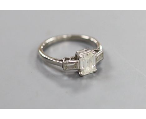   A white metal and emerald cut single stone diamond ring, with baguette cut diamond set shoulders,size J, gross 3.1 grams, t