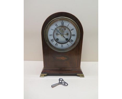 A mahogany inlaid striking mantle clock with exposed escapement and enamel dial and brass feet, 29cm tall, cracks to dial, ca