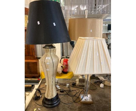 Modern table lamp with shade having tapering glass column on a copper finish square base together with a modern ceramic balus