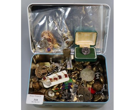 Metal tin containing a large collection of Military and other buttons, pin badges, enamel badges, crested spoons, novelty key