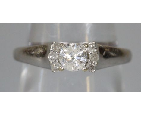 Diamond solitaire ring set in 18ct white gold with three diamonds set to either side.  Ring size P 1/2.  Weight approx 3.1 gr