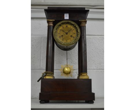 A mahogany portico mantel clock with drum head movement.