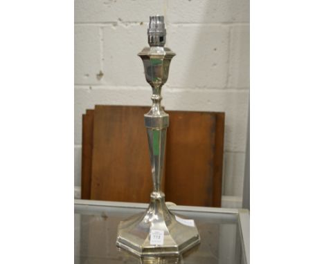 A silver candlestick converted to a table lamp.