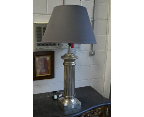 A large chromed metal column style table lamp.