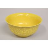 A CHINESE YELLOW GROUND PORCELAIN DRAGON BOWL, the exterior with carved dragons and stylised clouds,