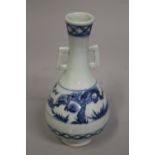 A CHINESE BLUE AND WHITE PORCELAIN TWIN HANDLE VASE, 21cm high.