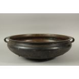 A LARGE 19TH CENTURY INDIAN OR SOUTH EAST ASIAN BRONZE TWIN HANDLE URLI, 59cm diameter. *Note: a