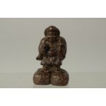 A BRONZE OKIMONO OF A MAN ON A RAFT, 6cm high.