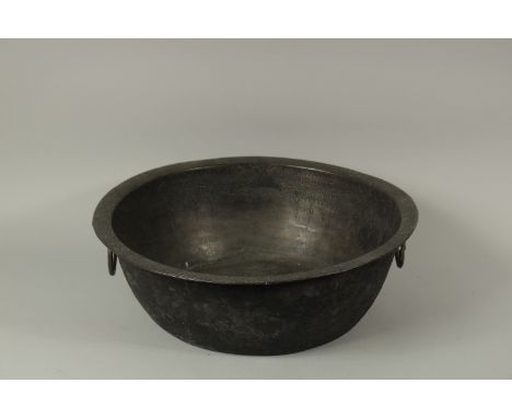 A VERY LARGE AND FINE EARLY ISLAMIC BRONZE BOWL, with twin handles and fine Kufic calligraphy to the rim, 49cm wide.