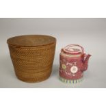 A PINK GROUND ENAMEL-PAINTED PORCELAIN TEAPOT, in fitted bamboo-woven case.