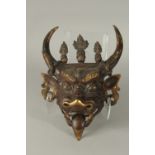 A 19TH CENTUTY TIBETAN OR CHINESE GILDED BRONZE BULL DEMON MASK, the horns with coiled snakes and