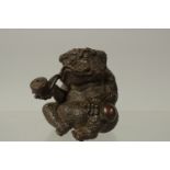 A BRONZE OKIMONO OF A TOAD smoking a pipe, 7cm high.