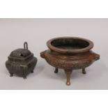A CHINESE BRONZE TRIPOD CENSER, with foliate designs and lion dog handles, the base with character
